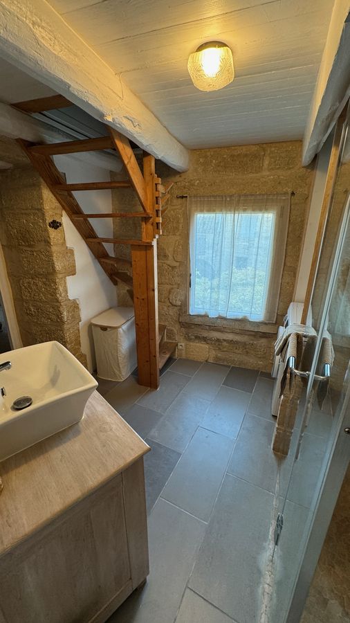 Le lavabo de la salle de bain et l'escalier de bois vers la tourelle