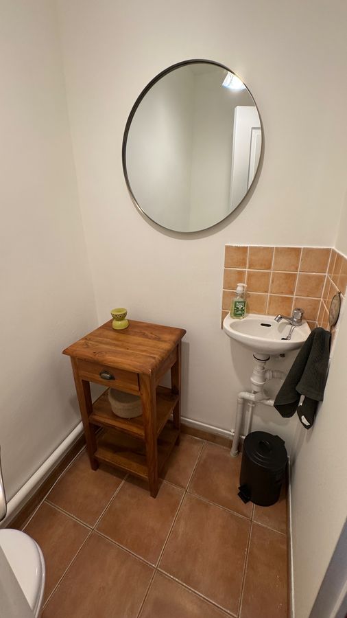 La salle d'eau séparée sur le palier, lavabo et miroir rond