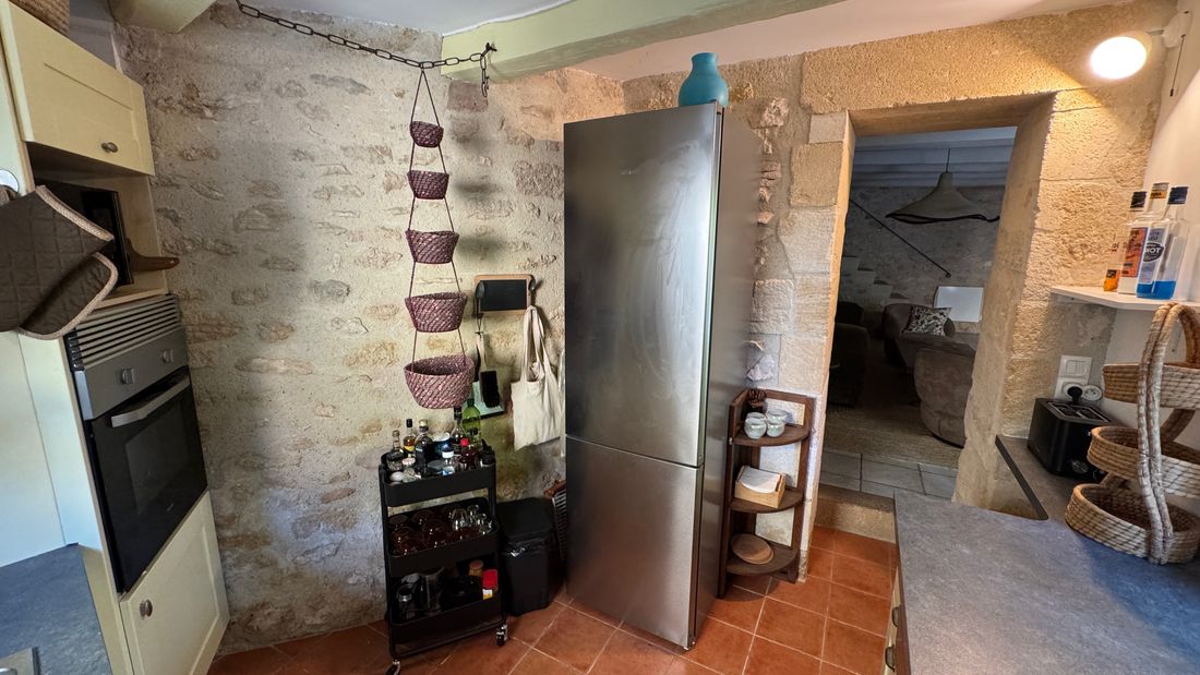 Le grand réfrigérateur et le passage en pierre vers le salon